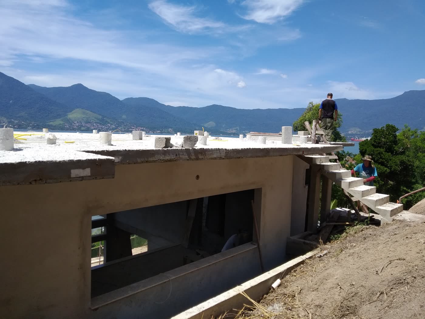 Laje de cobertura em concreto executada em residência de encosta, com vista para o mar