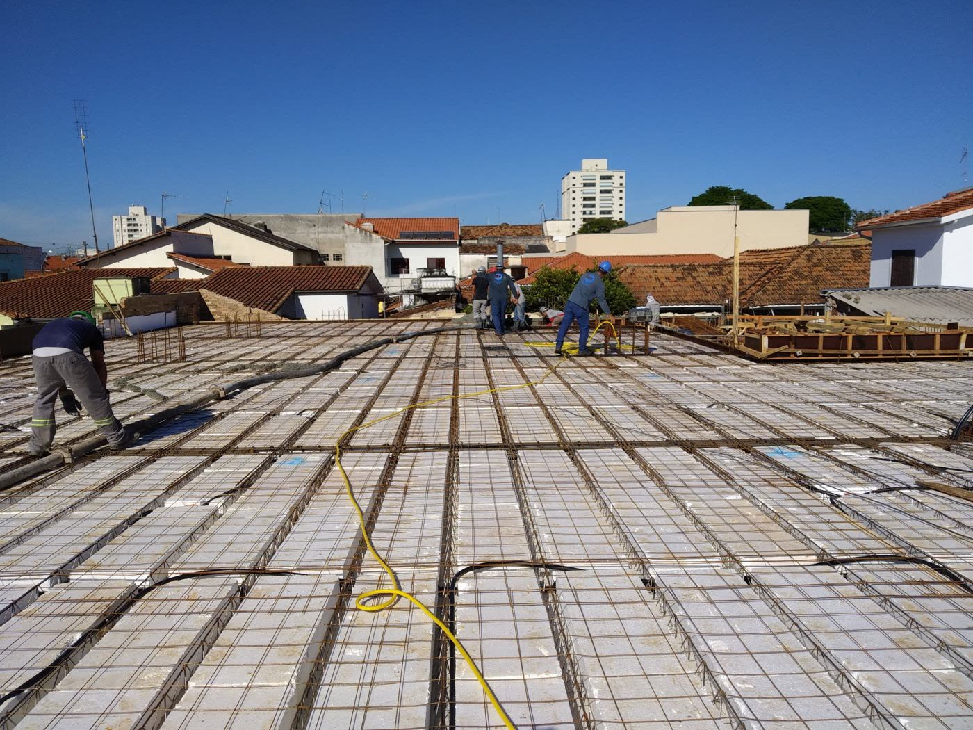 Armação de laje montada sobre as formas, com a equipe da VENCO Engenharia posicionando a ferragem antes da concretagem